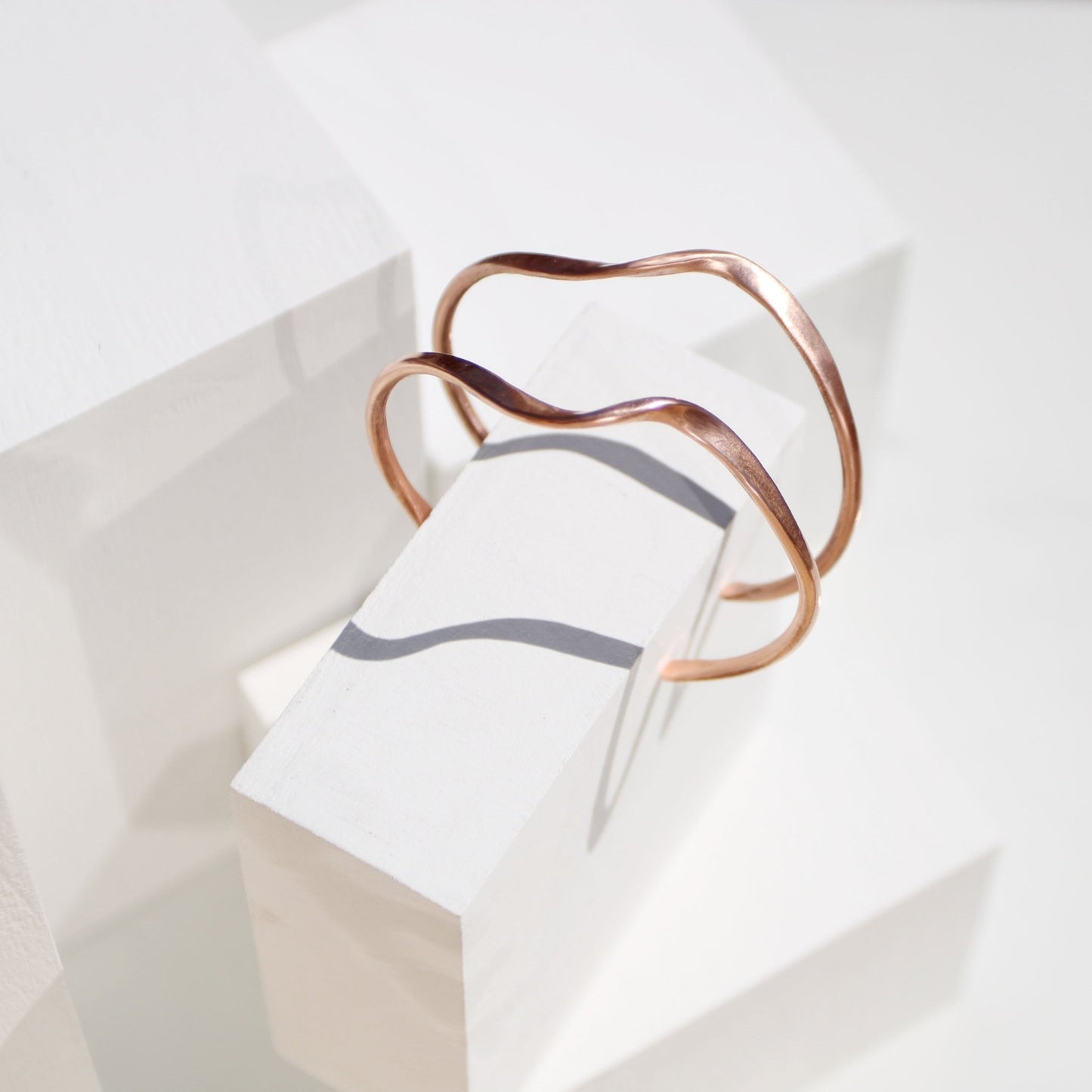 handmade copper wave cuff bracelet on white background