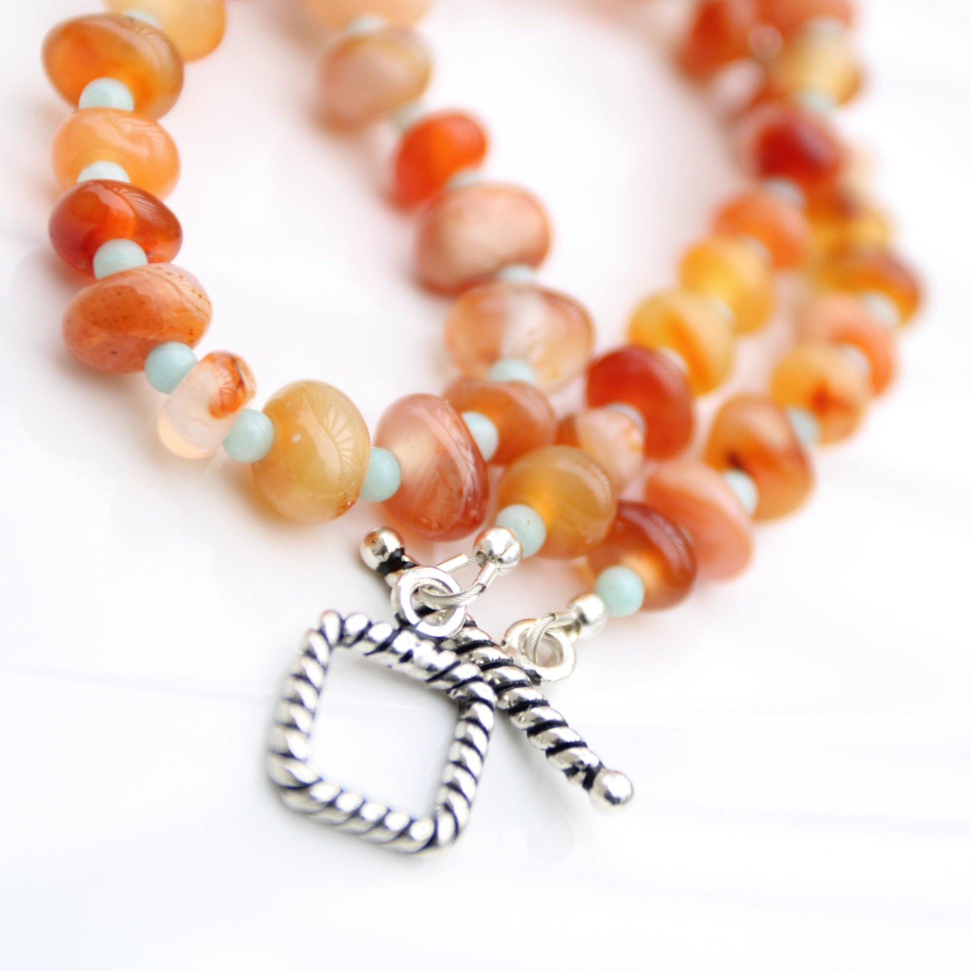 Light red botswana agate donut style beads accented with amazonite handmade in virginia carrie foscato design