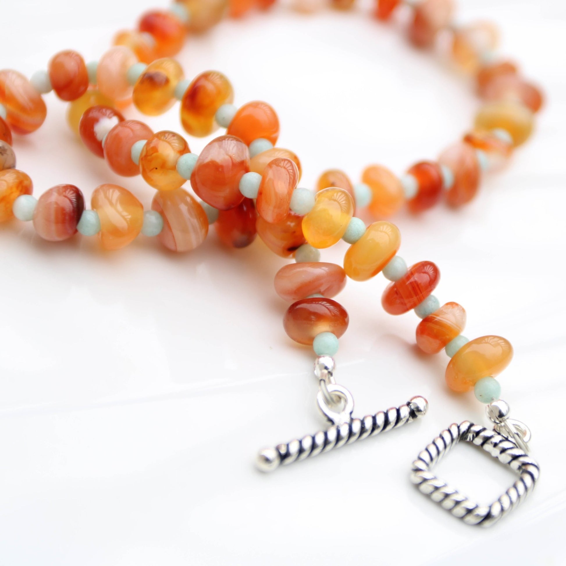 Light red botswana agate donut style beads accented with amazonite handmade in virginia carrie foscato design