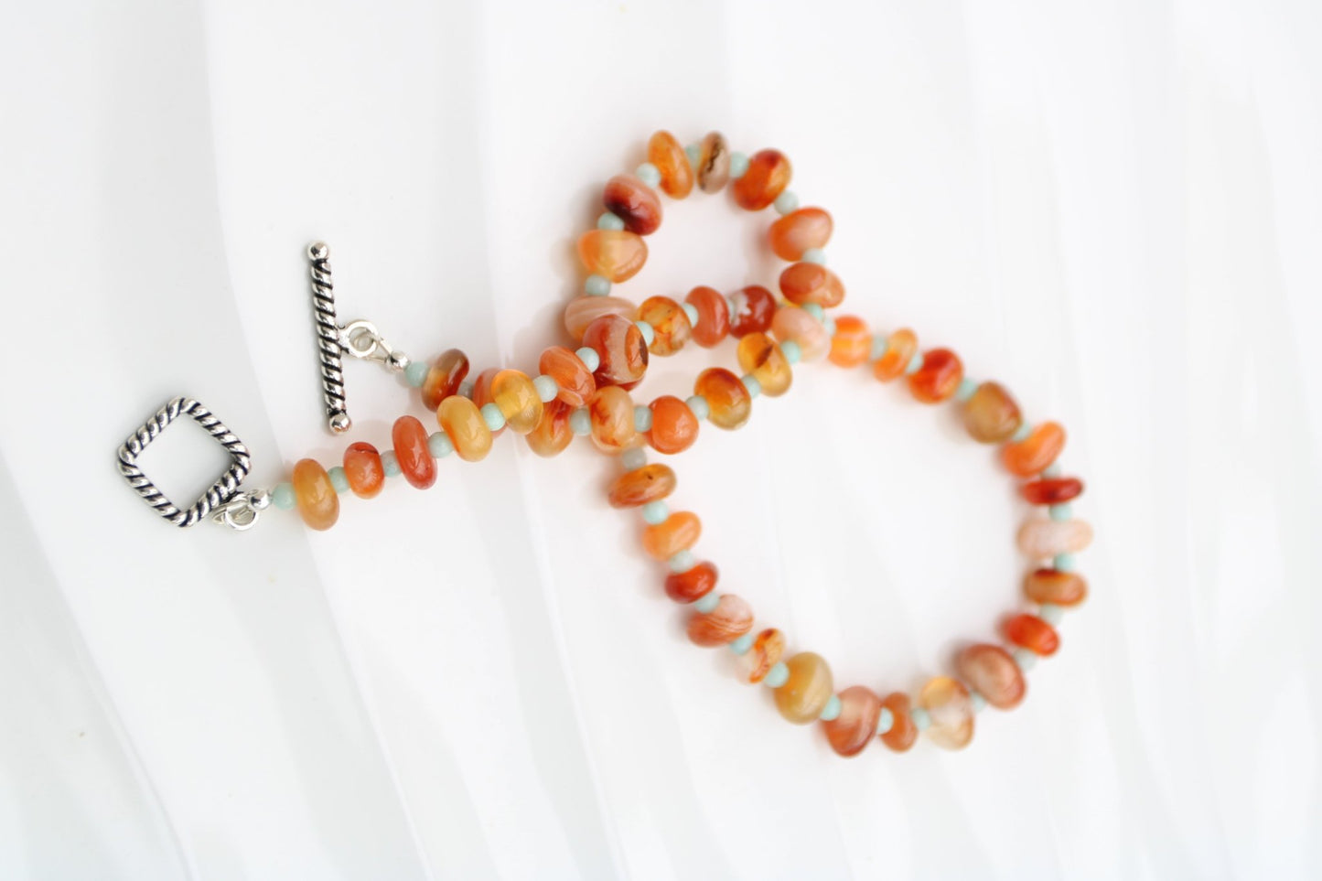 Light red botswana agate donut style beads accented with amazonite handmade in virginia carrie foscato design