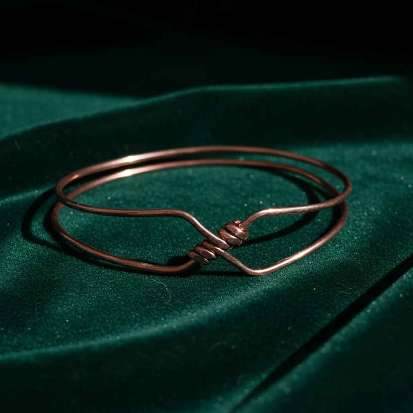 Copper bangle on draped forest-green velvet