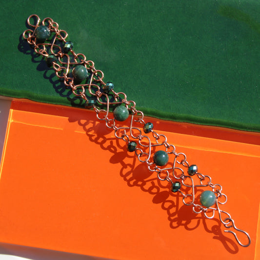 slinky wire wrapped copper cuff bracelet with green accent gemstones handmade carrie foscato design