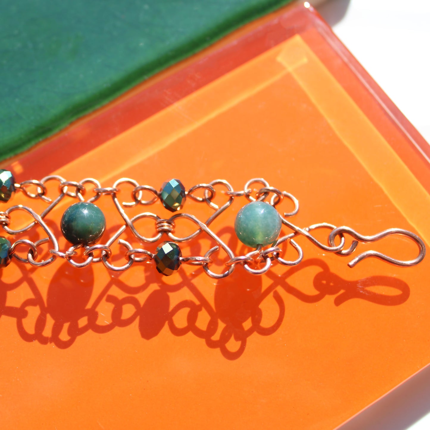 slinky wire wrapped copper cuff bracelet with green accent gemstones handmade carrie foscato design