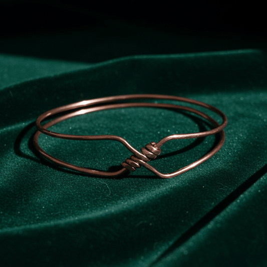 Copper bangle on draped forest-green velvet