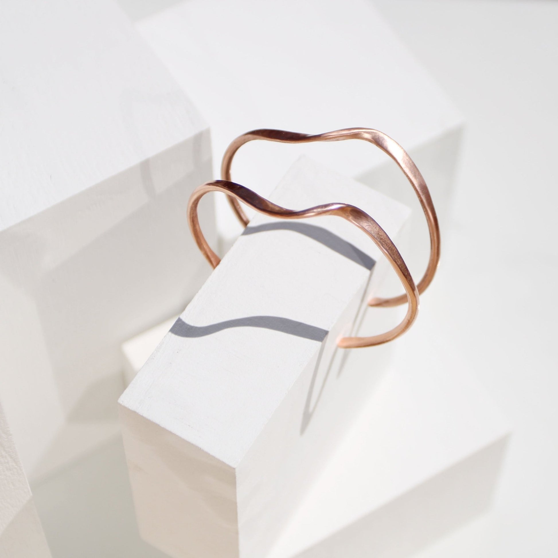 handmade copper wave cuff bracelet on white background