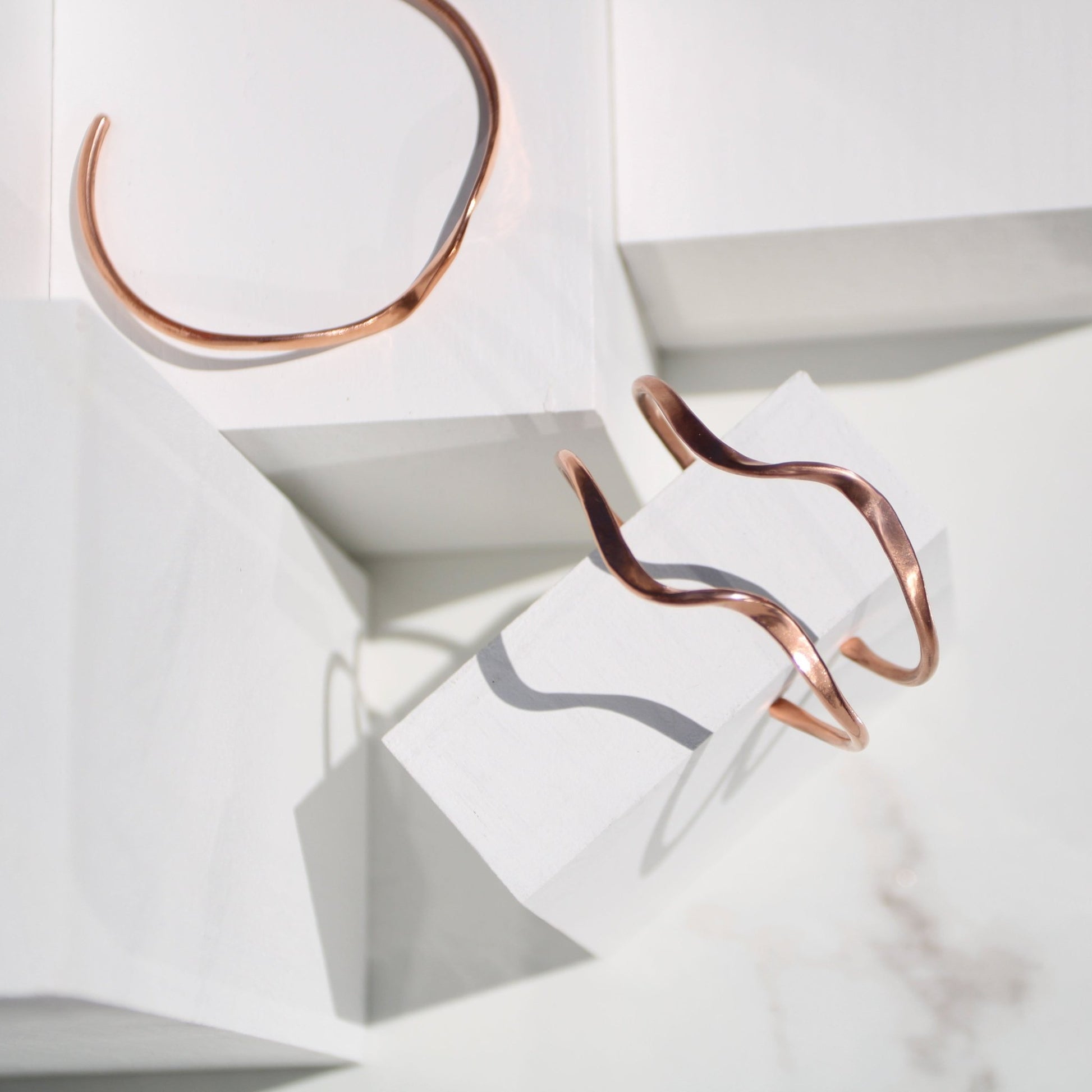 handmade copper wave cuff bracelet on white background