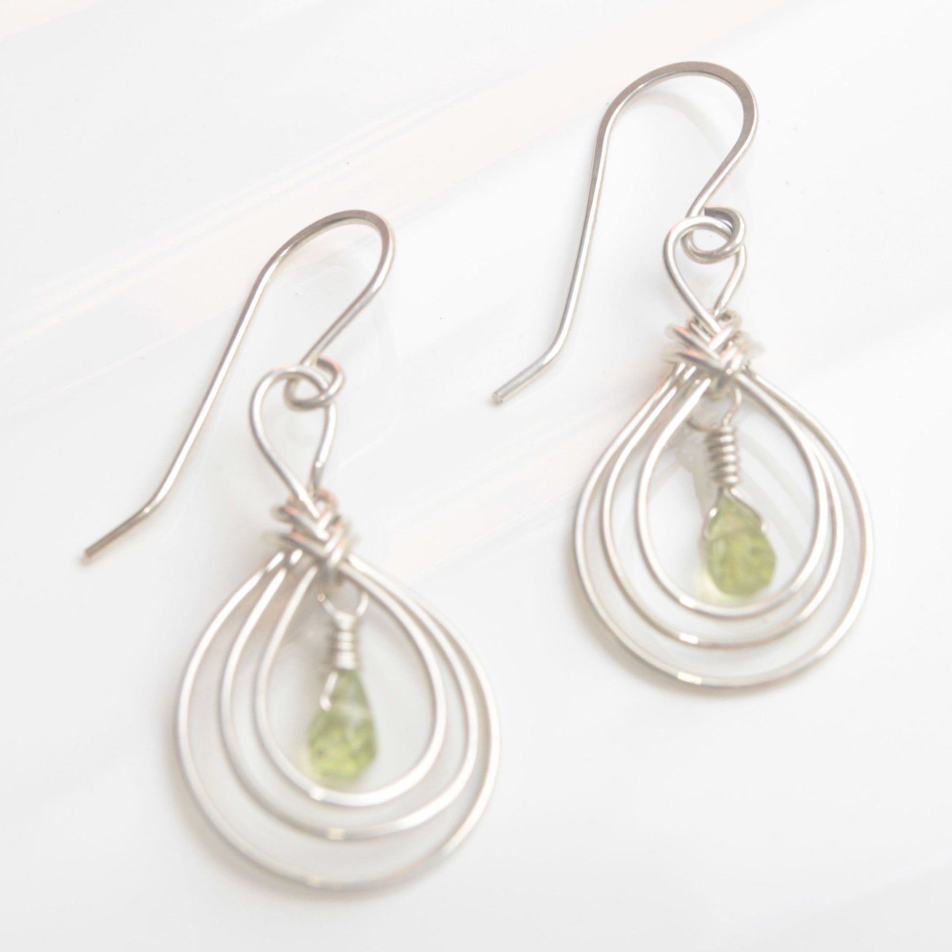Handmade USA. sterling silver earrings with ancient Pipa Knot Design and peridot briolette gemstones. Carrie Foscato Design