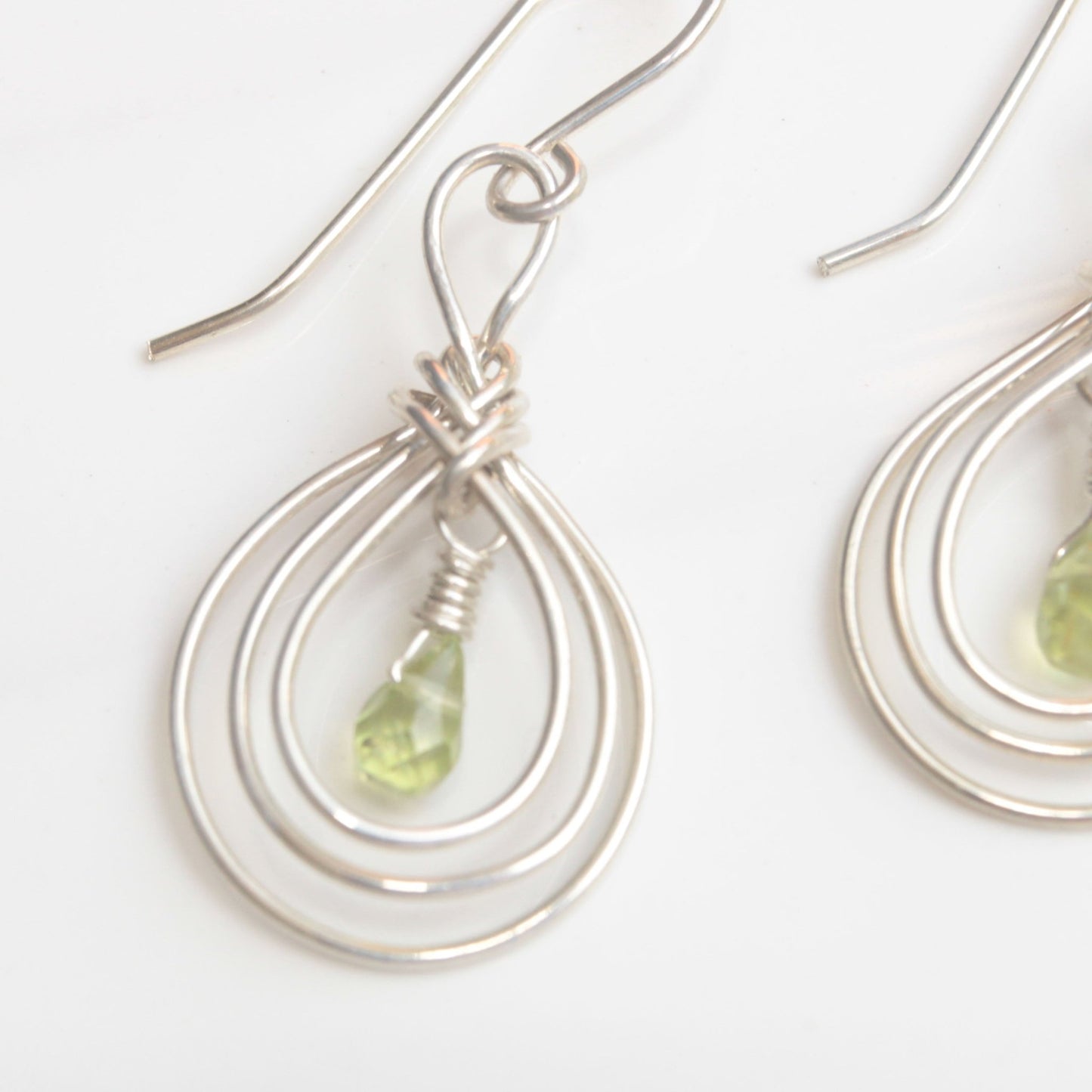 Handmade USA. sterling silver earrings with ancient Pipa Knot Design and peridot briolette gemstones. Carrie Foscato Design