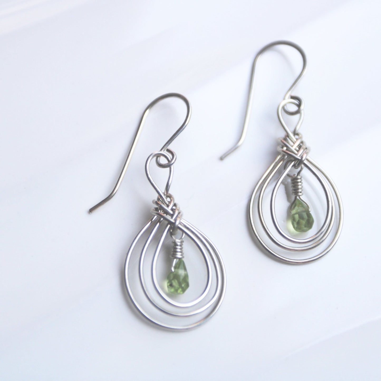 Handmade USA. sterling silver earrings with ancient Pipa Knot Design and peridot briolette gemstones. Carrie Foscato Design