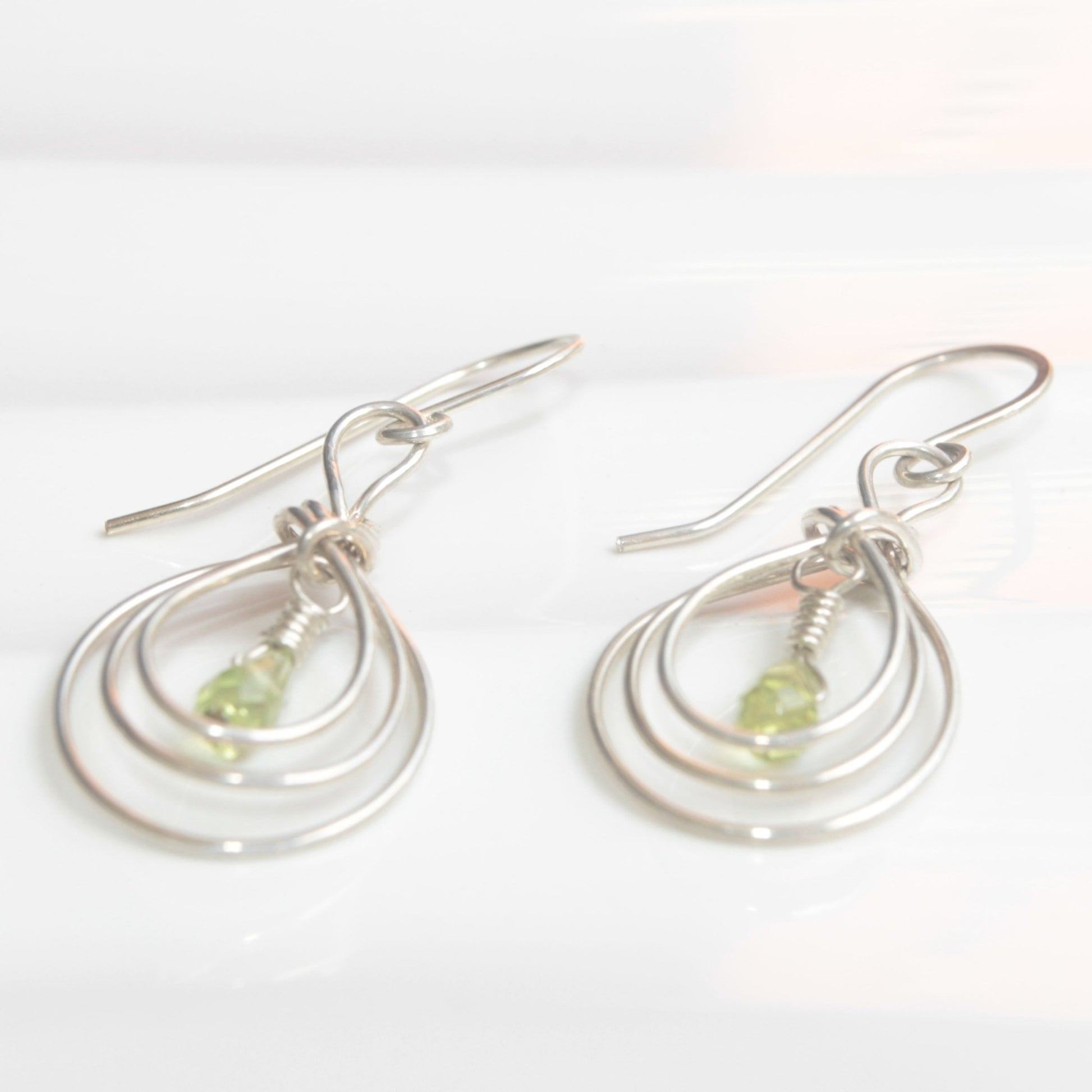 Handmade USA. sterling silver earrings with ancient Pipa Knot Design and peridot briolette gemstones. Carrie Foscato Design