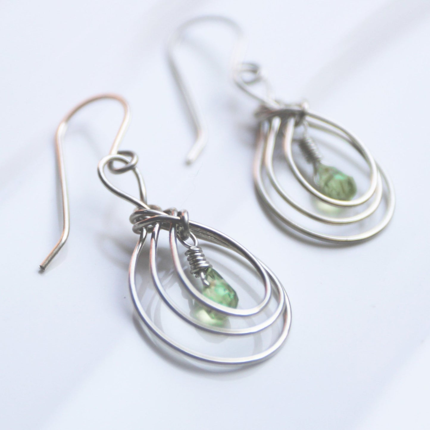 Handmade USA. sterling silver earrings with ancient Pipa Knot Design and peridot briolette gemstones. Carrie Foscato Design
