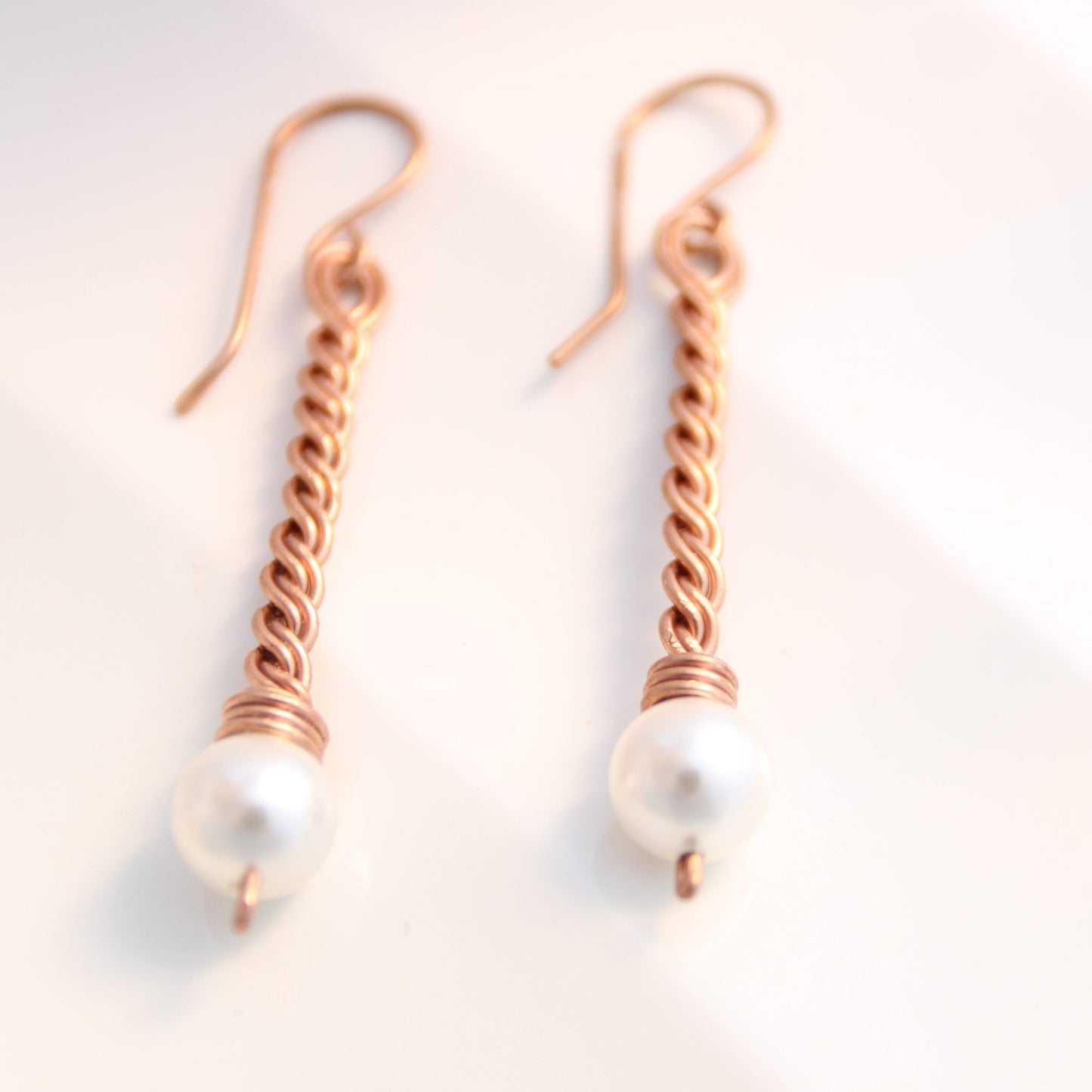 Close up of hand-twisted solid copper bar jewelry with genuine pearl