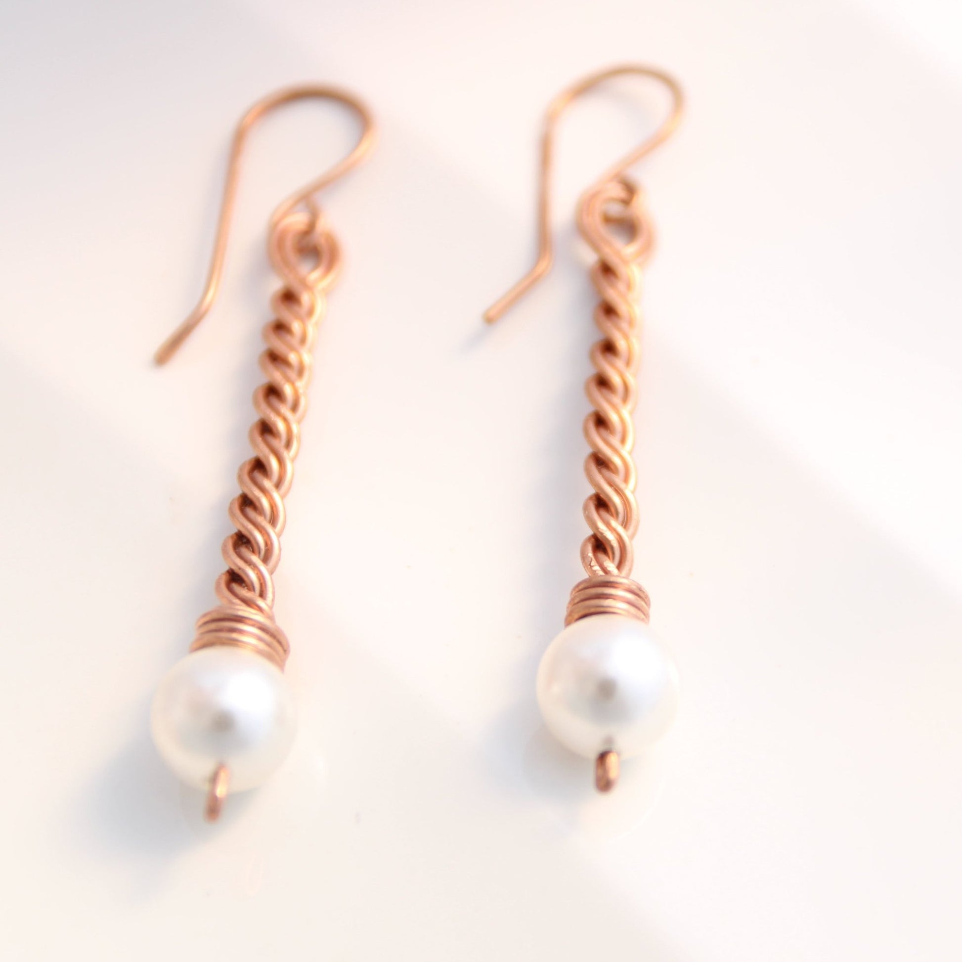 Close up of hand-twisted solid copper bar jewelry with genuine pearl