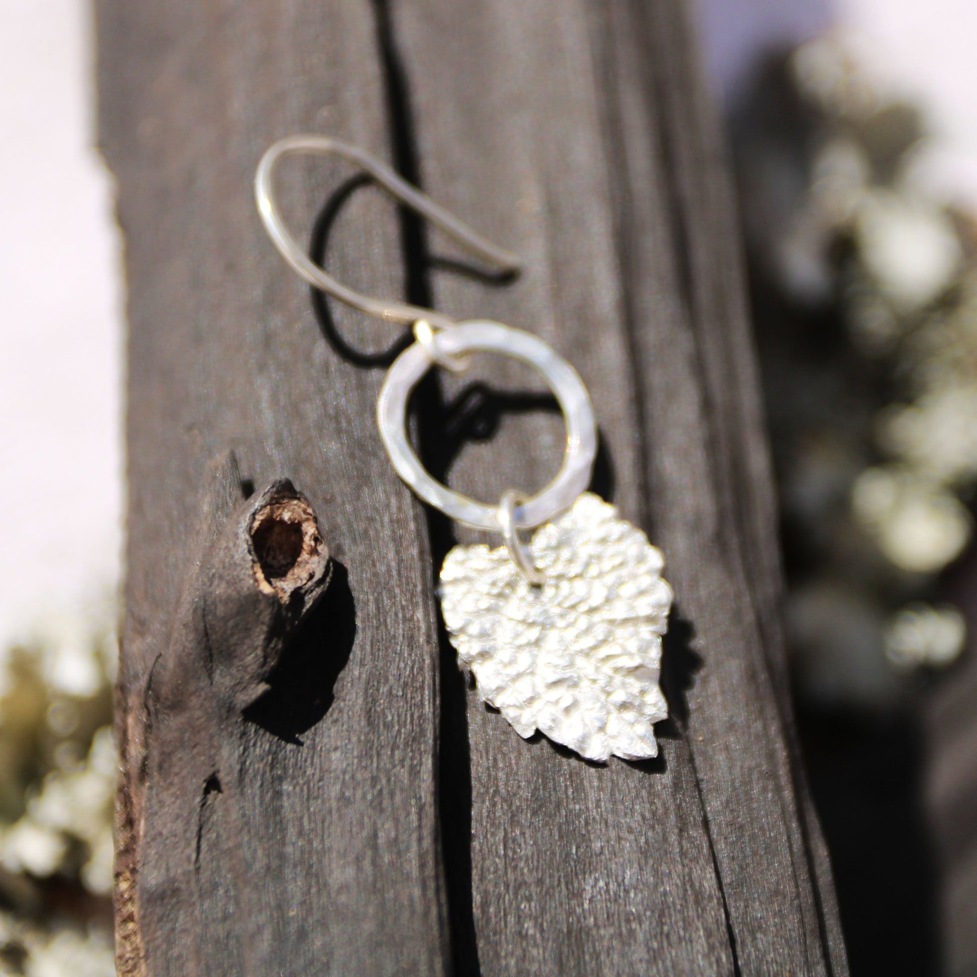 lemon balm fine silver charm earrings on dark wood background handmade carrie foscato design
