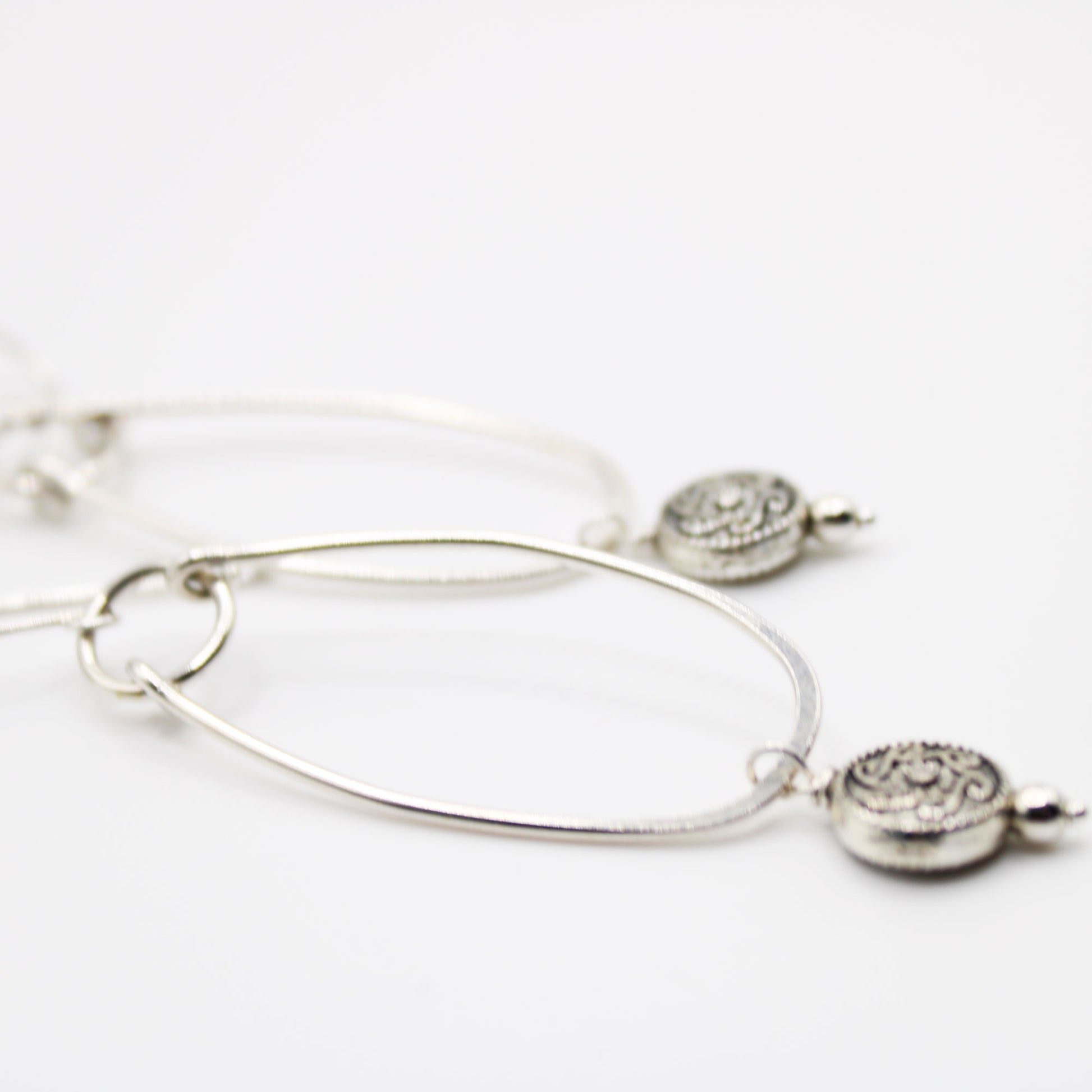 sterling silver oblong hoop earrings with silver medallion accent bead