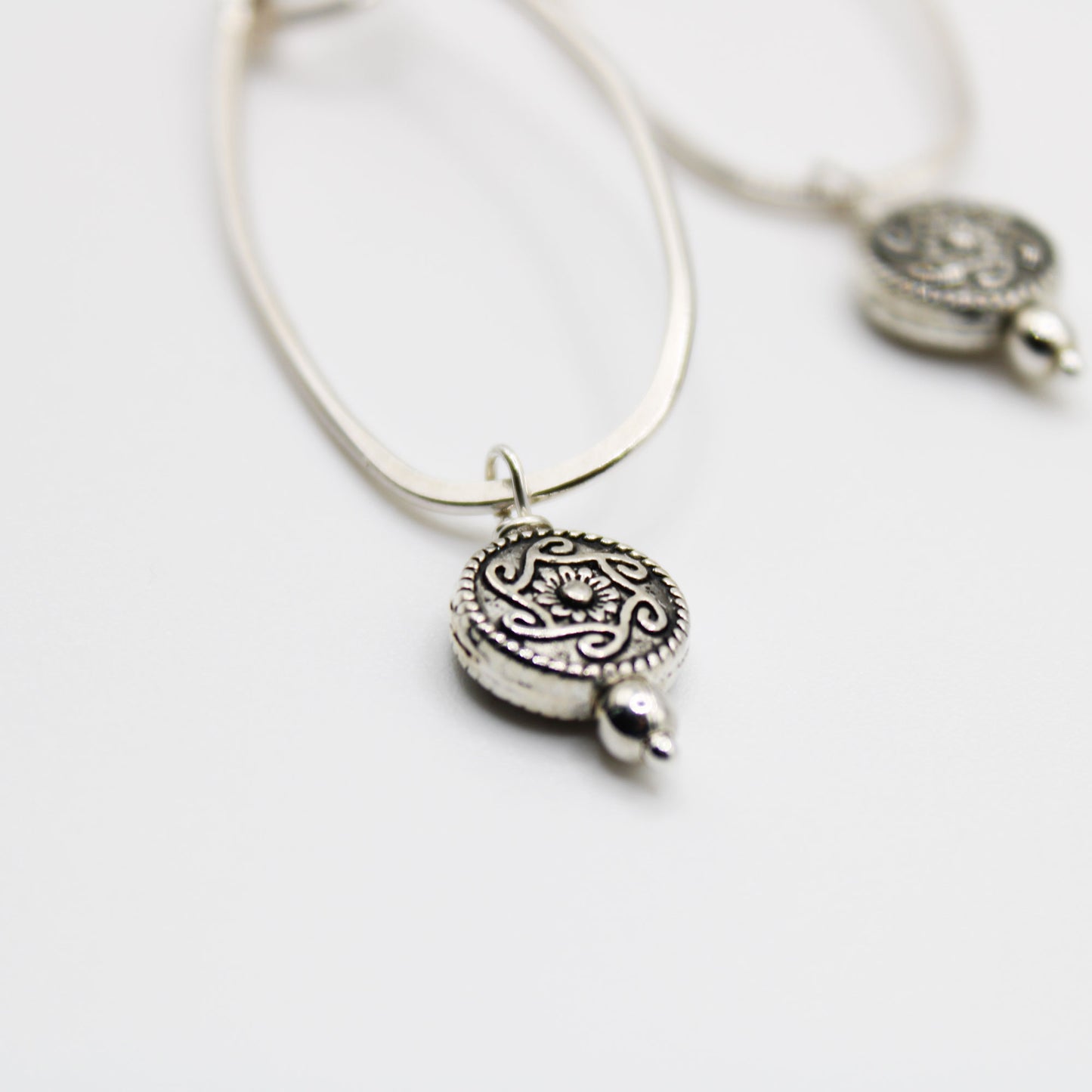 sterling silver oblong hoop earrings with silver medallion accent bead