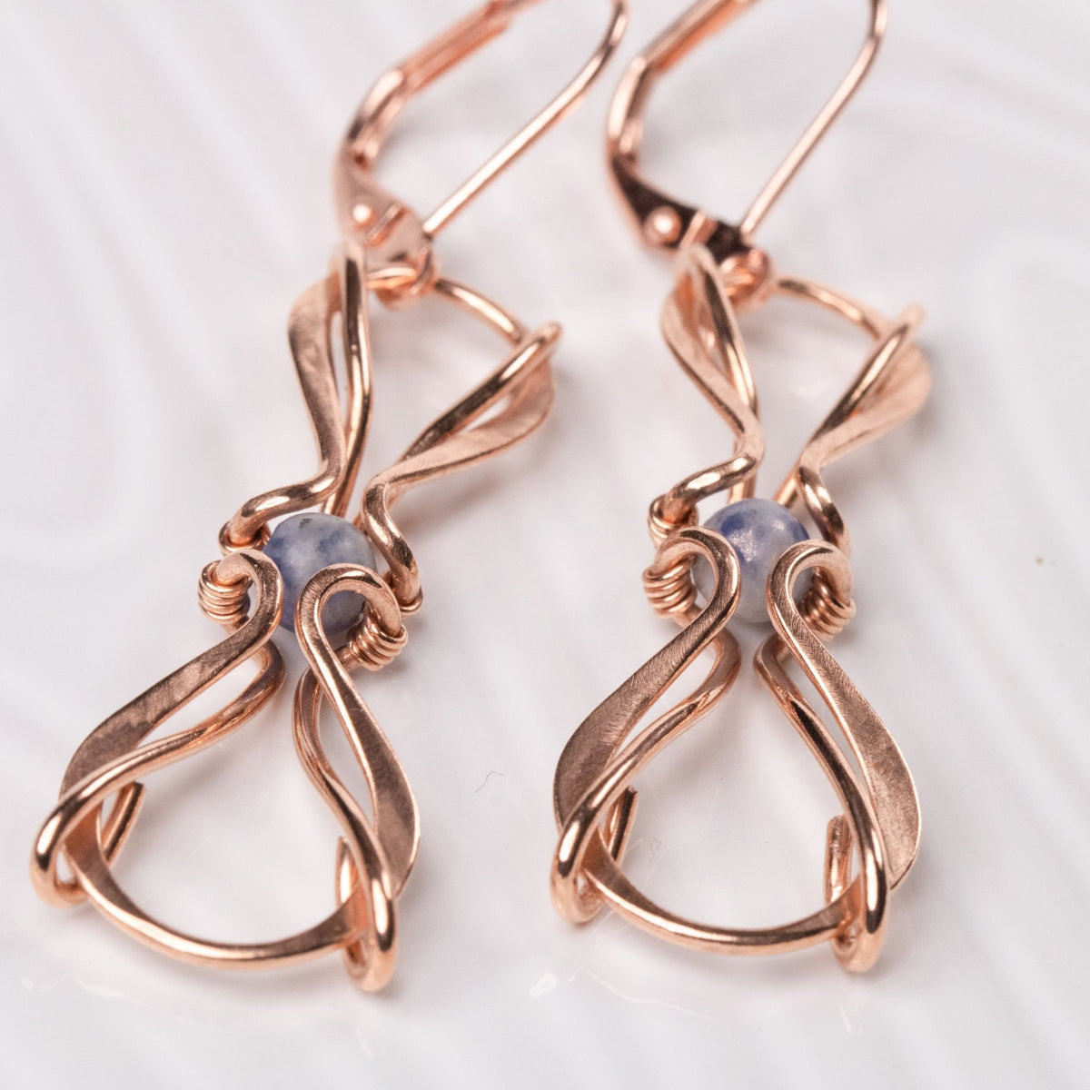 closup of wire wrapped copper earrings with blue stones carrie foscato design