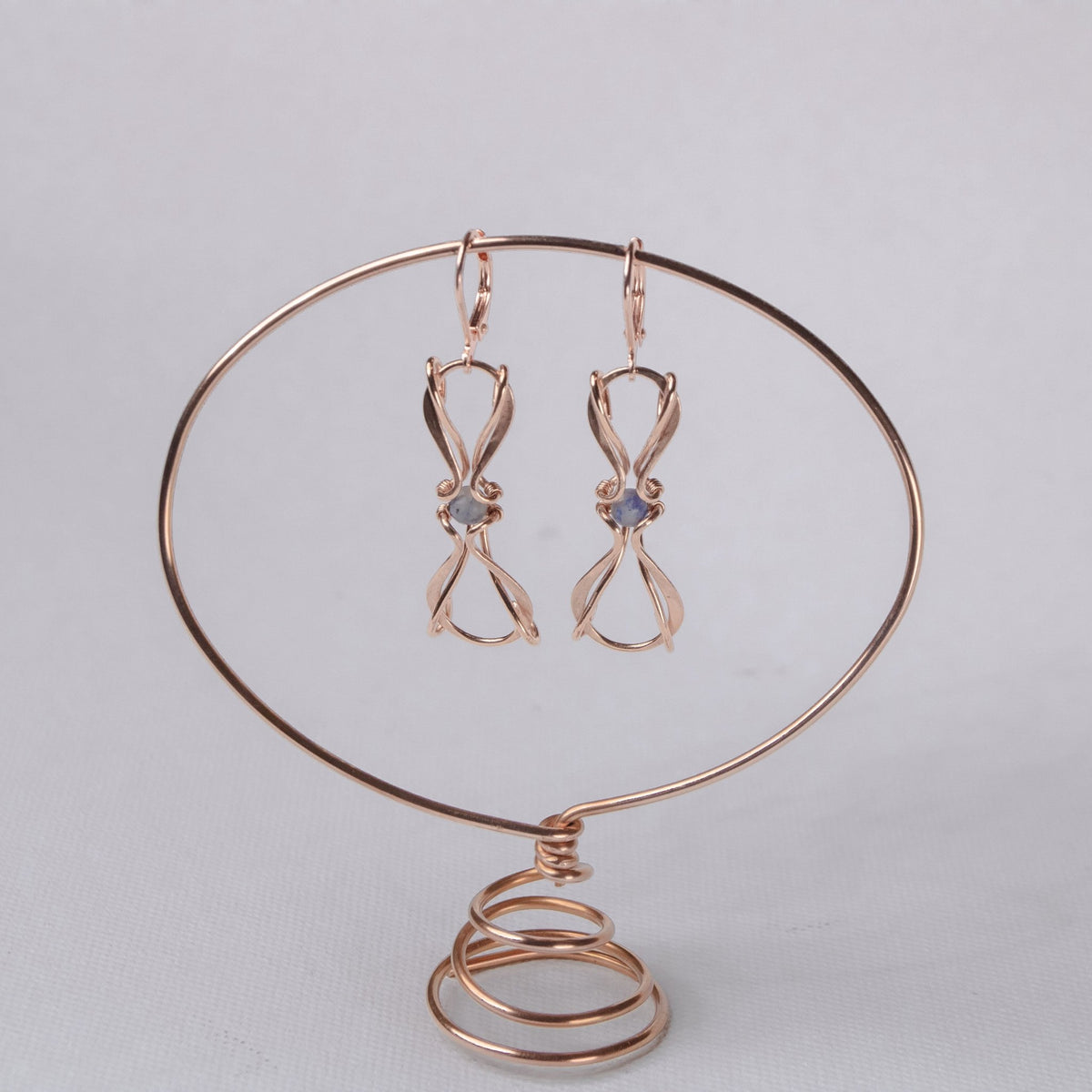 copper wire wrapped earrings on copper oval display