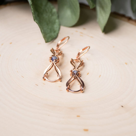copper wire wrapped earrings on wood
