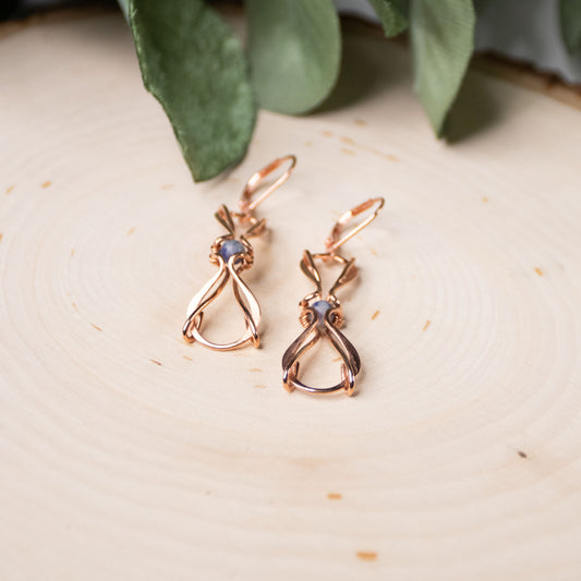 copper wire wrapped earrings on wood