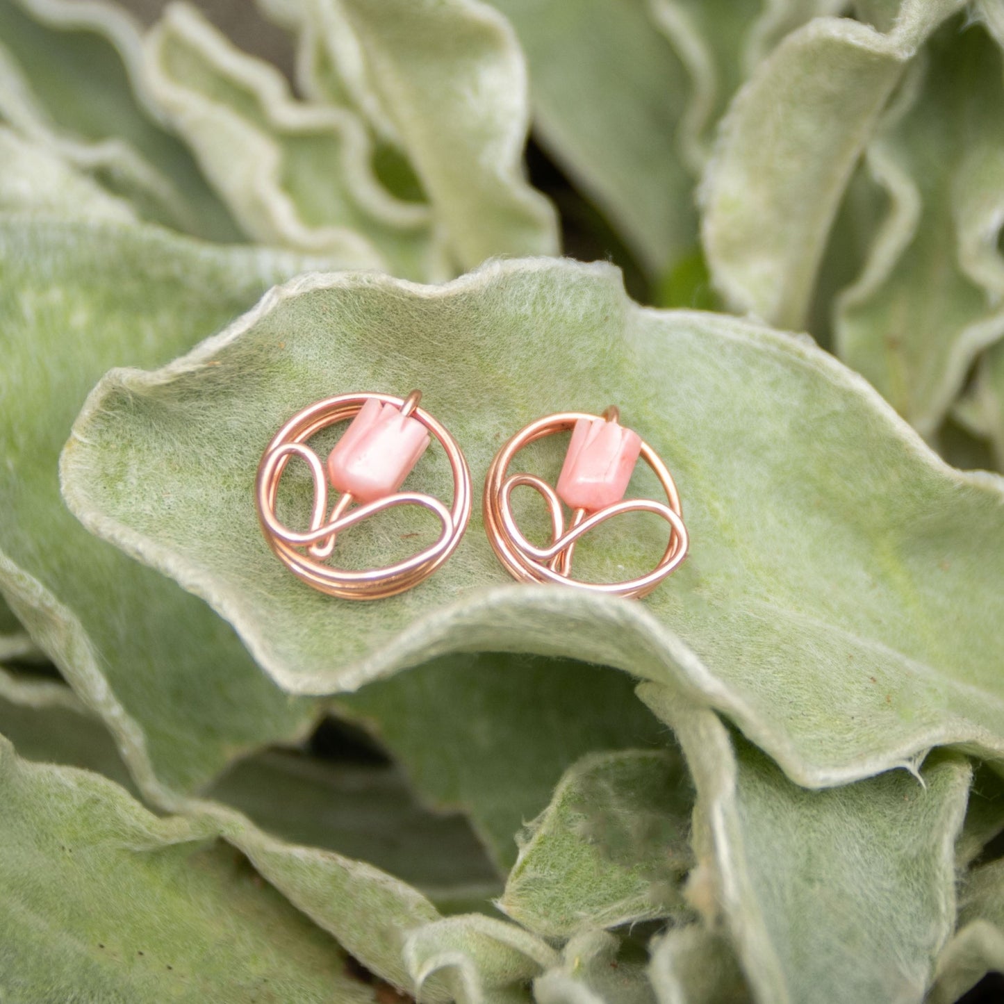 Copper flower bud earring with mother of pearl dangle on lamb's ear foliage