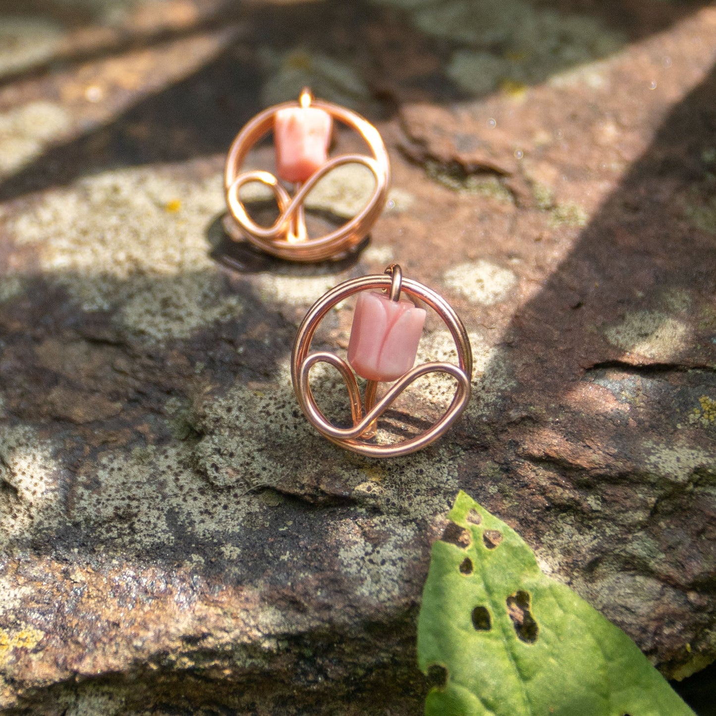 Pair of copper flower bud stud earrings nestled in white sedum blooms